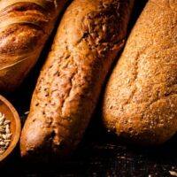 Various bread with grain in a bowl on the table.