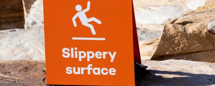 Sign showing warning of caution that rocks are slippery when wet.
